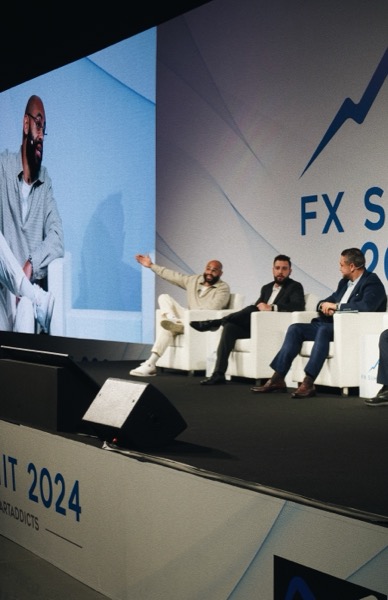 Ken Chigbo speaking on stage at a professional FX trading summit